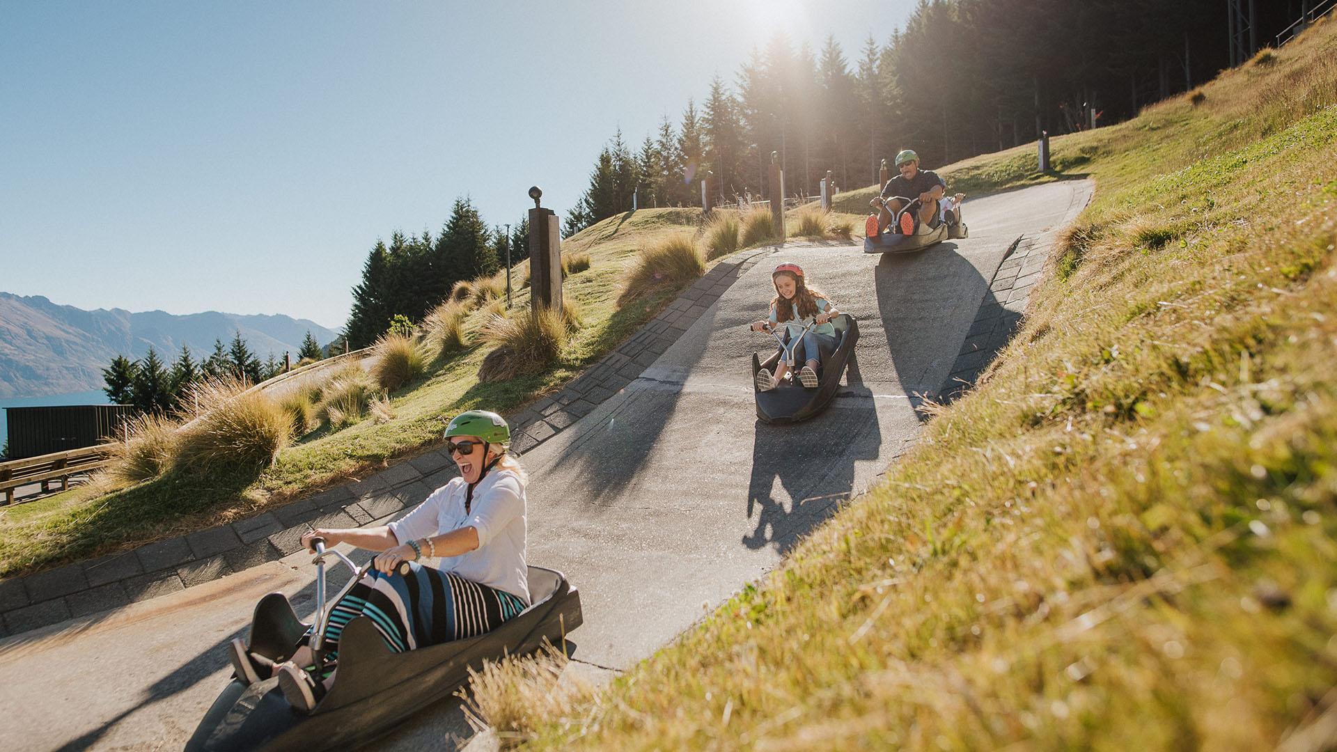 Family going down the luge track and having fun