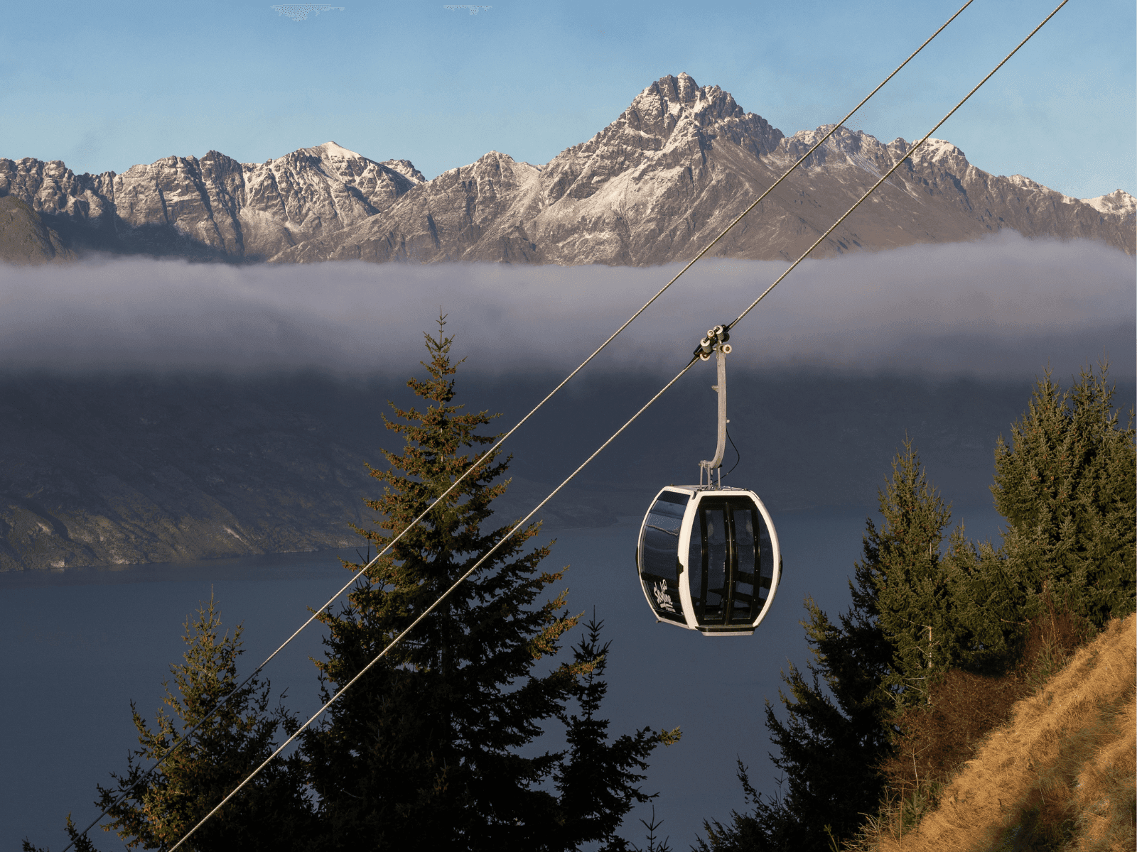 Gondola going up mountain over mist