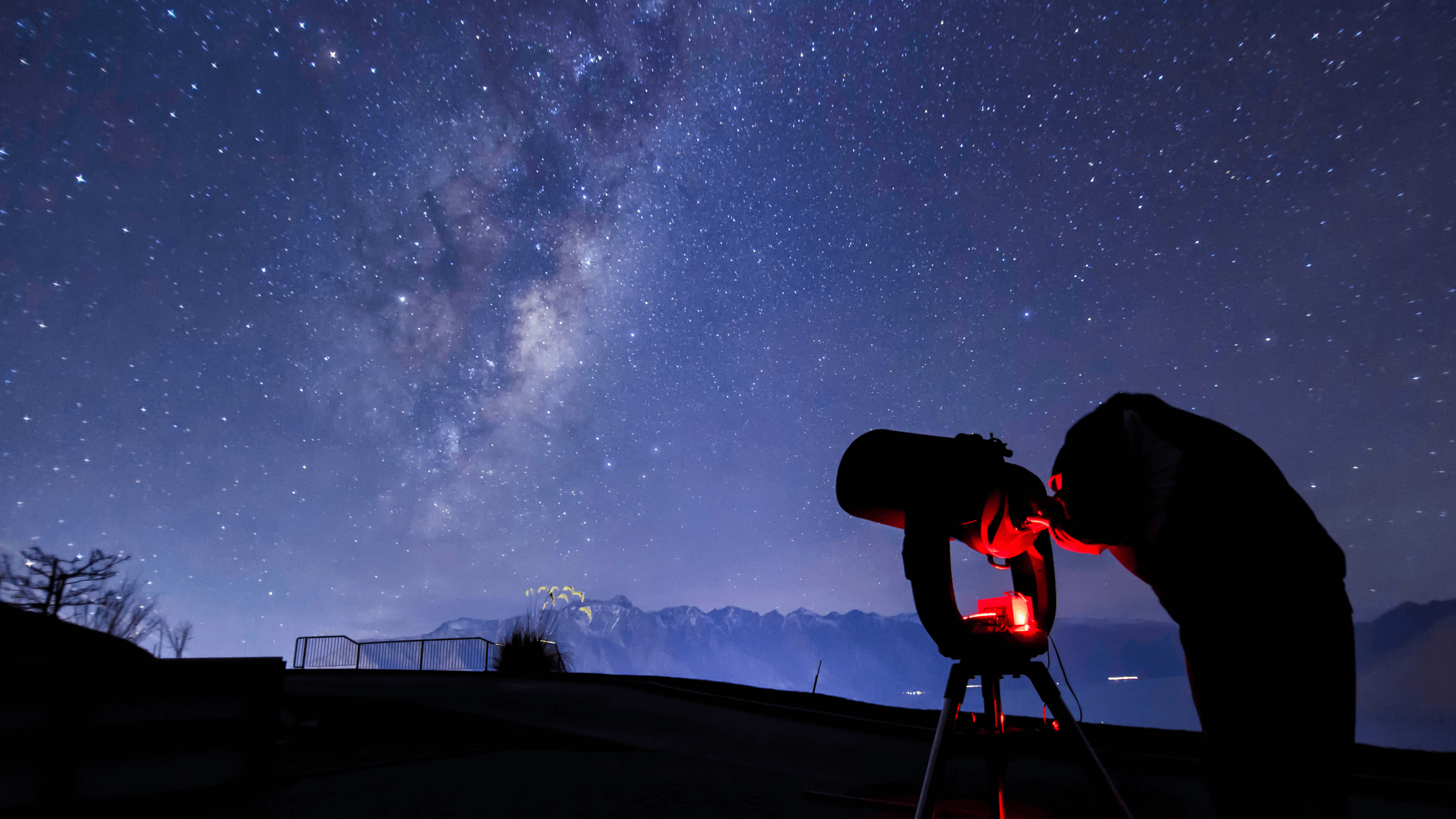 Telescope pointed at the milky way with person looking through the lens