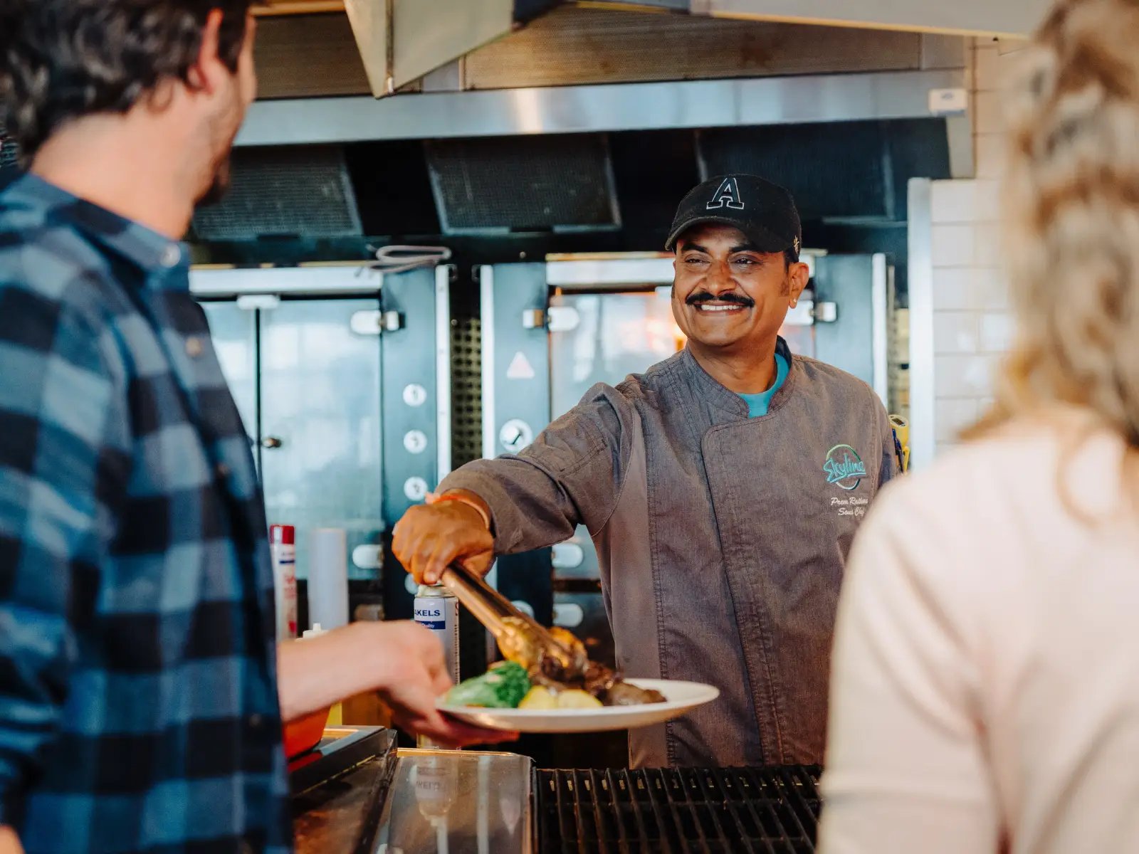 Stratosfare Restaurant chef serving freshly prepared food to guests at Skyline Queenstown