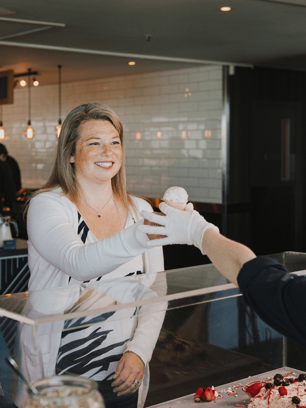 Lady getting an ice cream from a restaurant worker