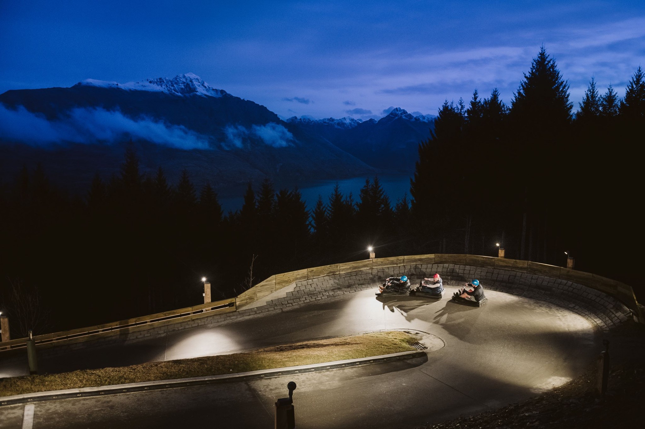 Skyline Queenstown Twilight Luge riders descending the track at sunset with glowing alpine views.