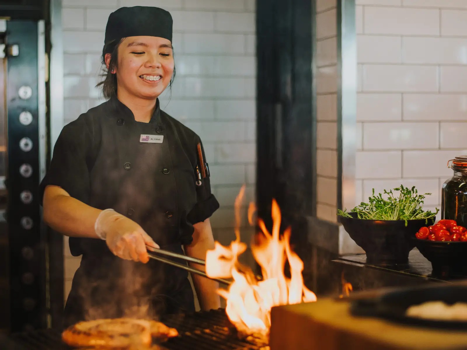 Stratosfare Restaurant chef flame grilling food in the open kitchen at Skyline Queenstown