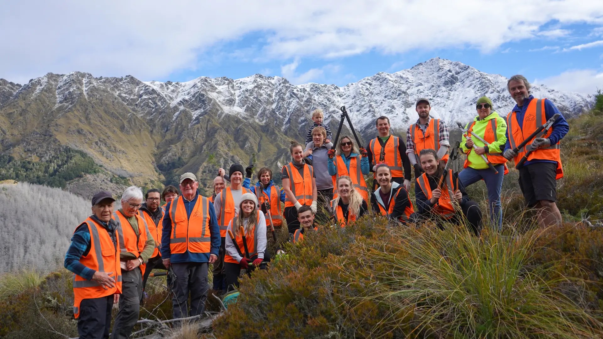 Volunteer group on Bob’s Peak in Queenstown with alpine mountain backdrop during a community conservation day