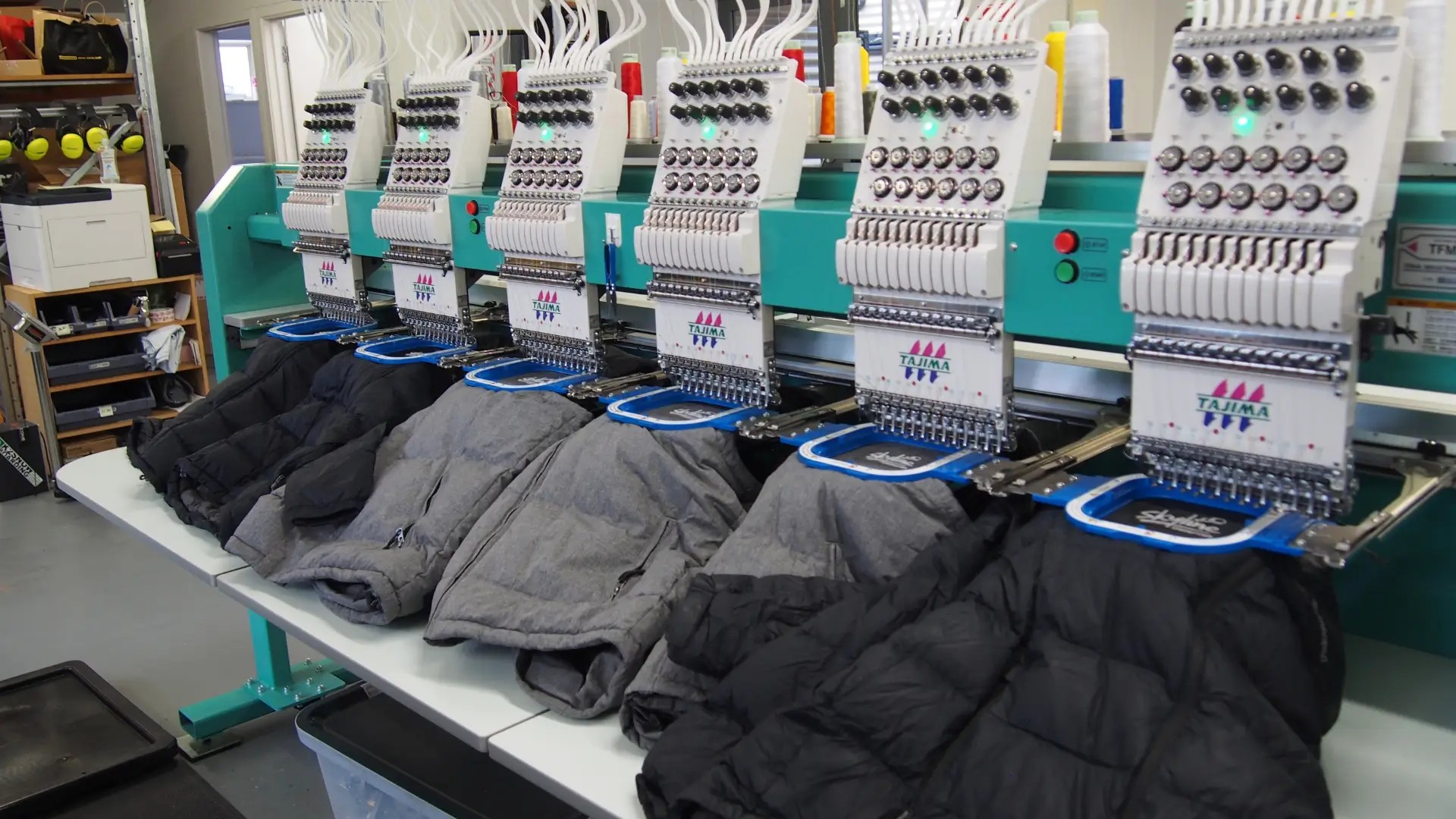 Skyline Queenstown uniforms with old logo being prepared for upcycling using industrial embroidery machines