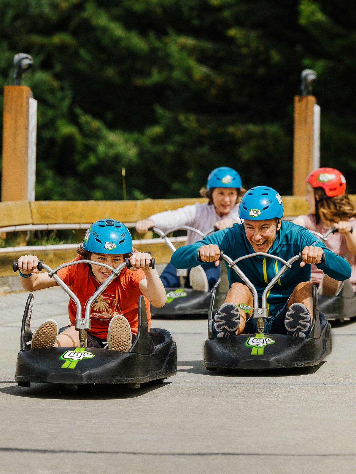 Family going down the luge track in luge carts
