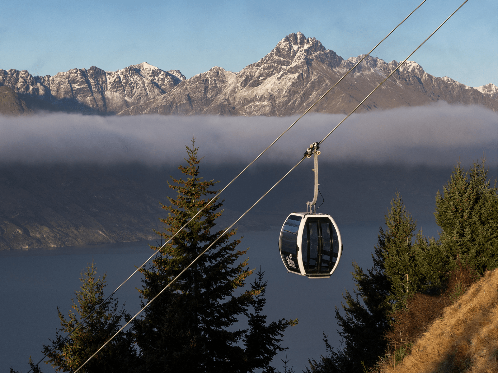 Gondola going up mountain over mist